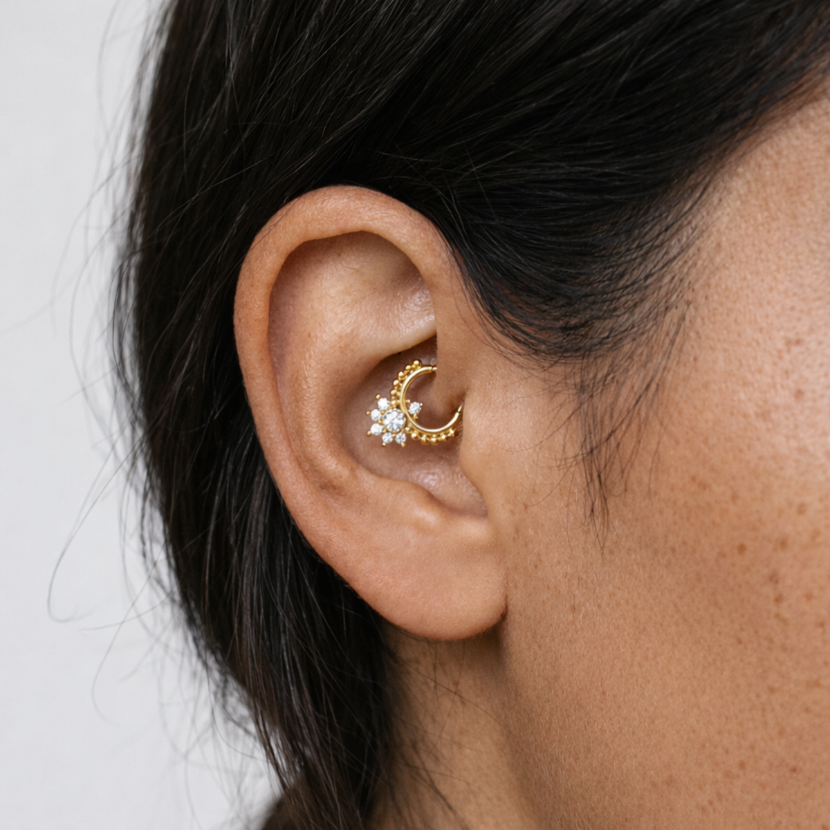 Anneau piercing Albane en titane gold avec zircon, porté au daith