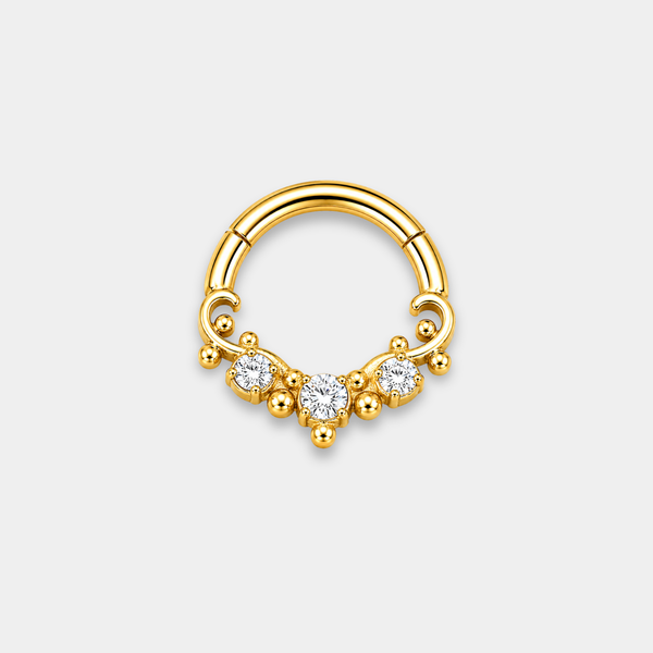 Anneau piercing Aurel en titane gold avec trois zircons sertis et détails perlés de face