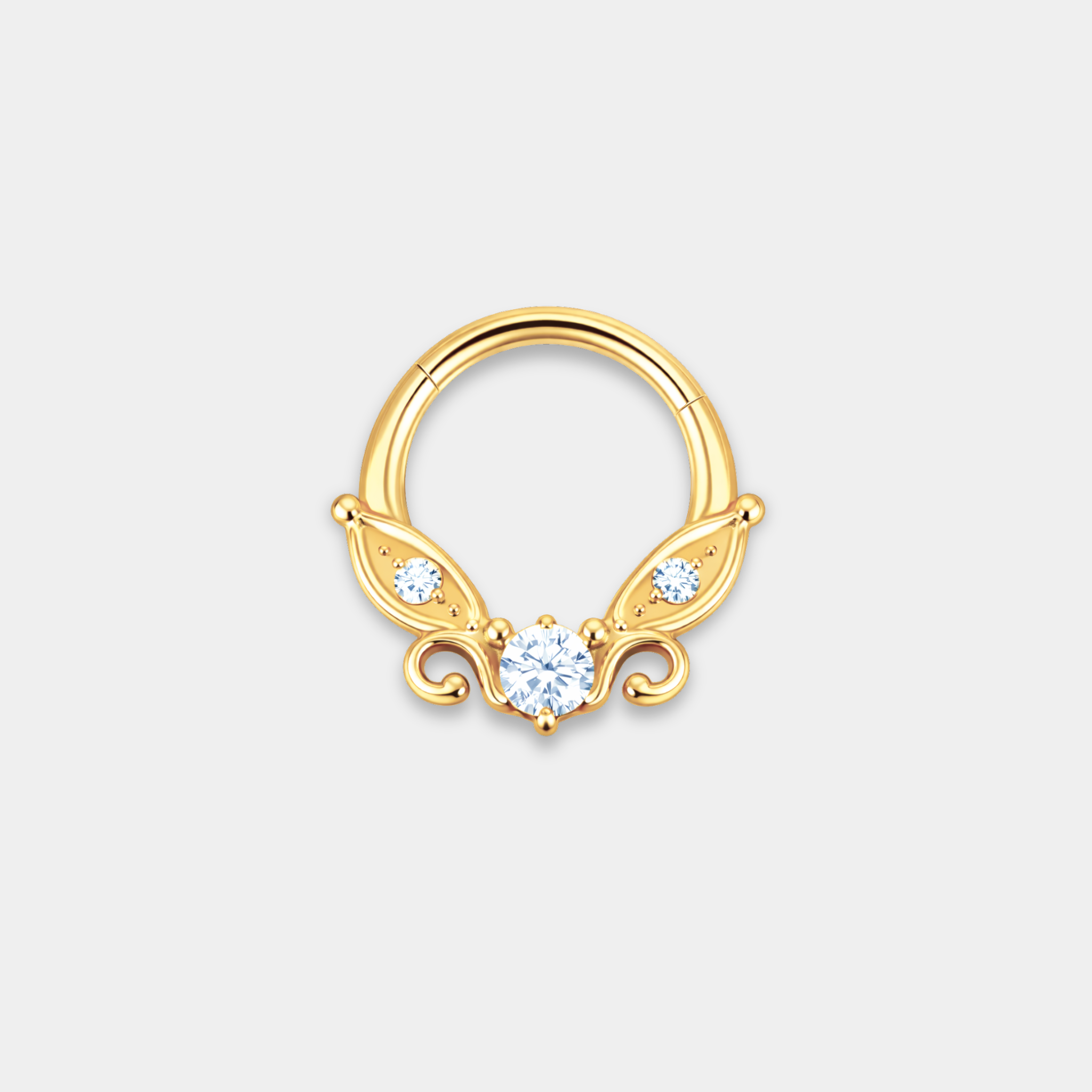 Anneau piercing Celia en titane gold avec zircon central serti, petits zircons latéraux et détails en forme d’ailes de face