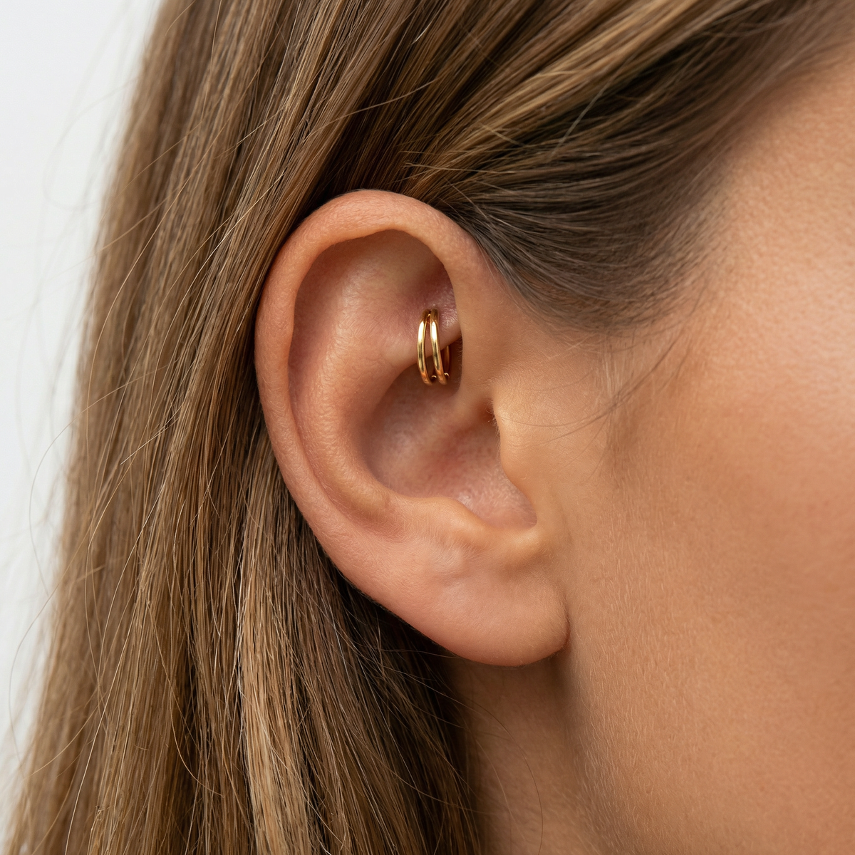 Anneau piercing Elian en titane gold, porté à l’oreille