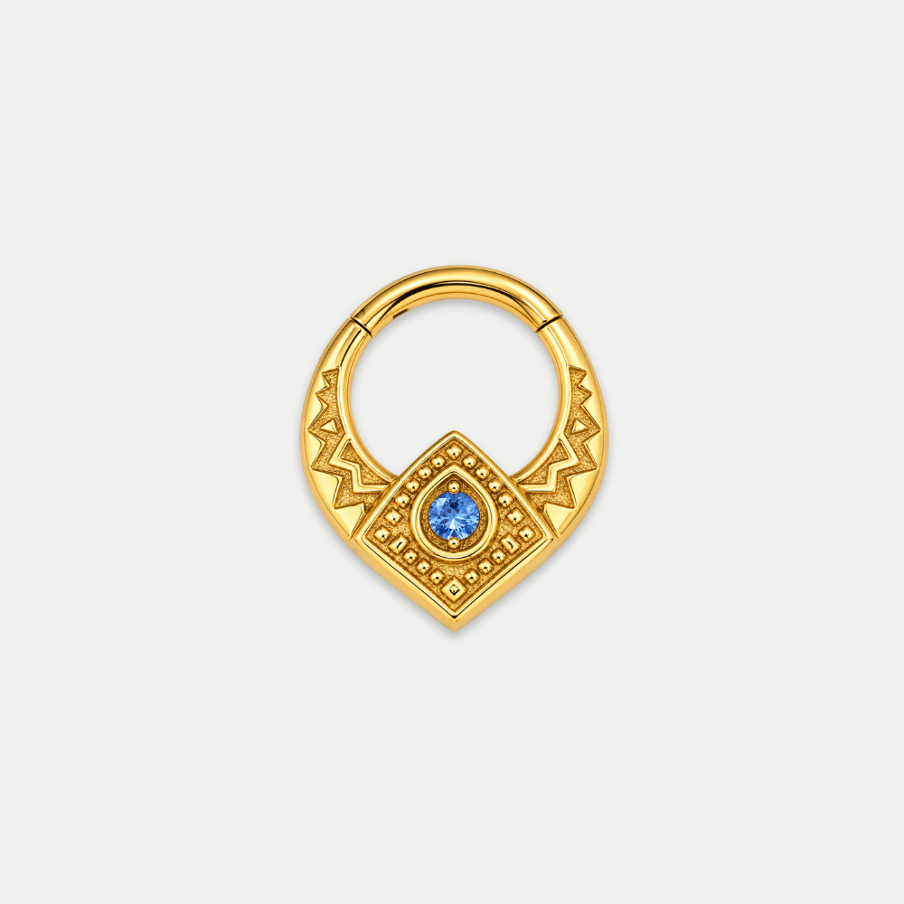 Anneau piercing Emblem en titane gold, motif géométrique ciselé et zircon central, zircon bleu, vu de face