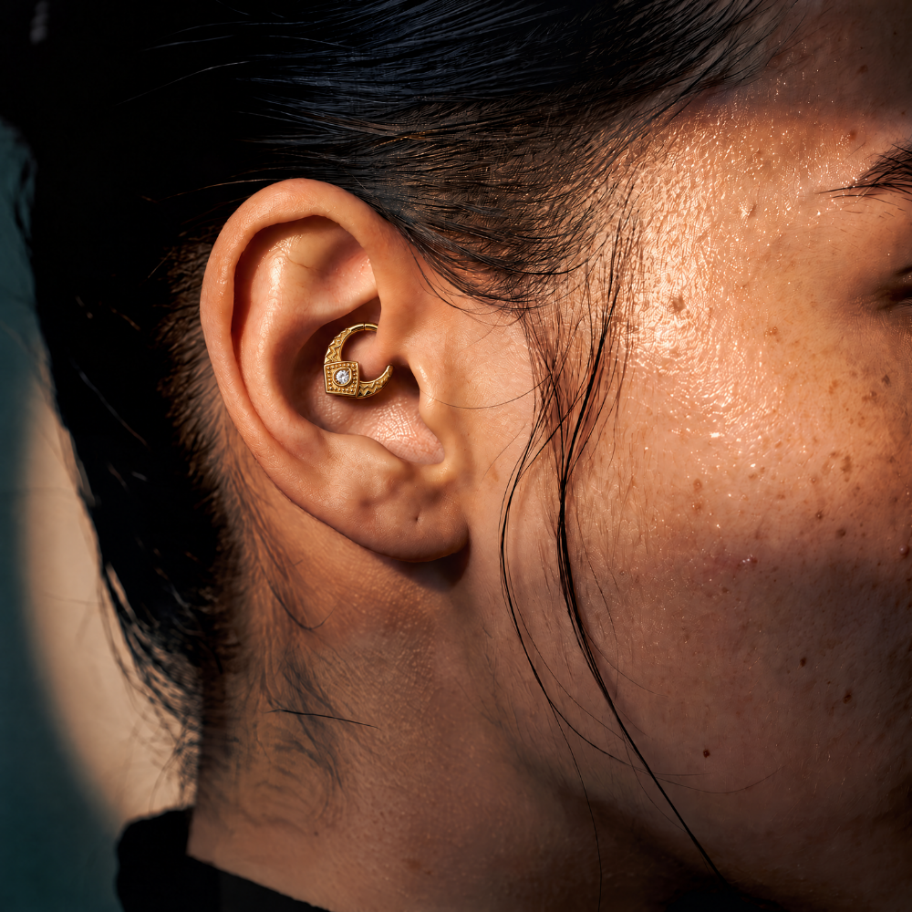 Anneau piercing Emblem en titane gold, motif géométrique ciselé et zircon central, zircon blanc, porté au daith