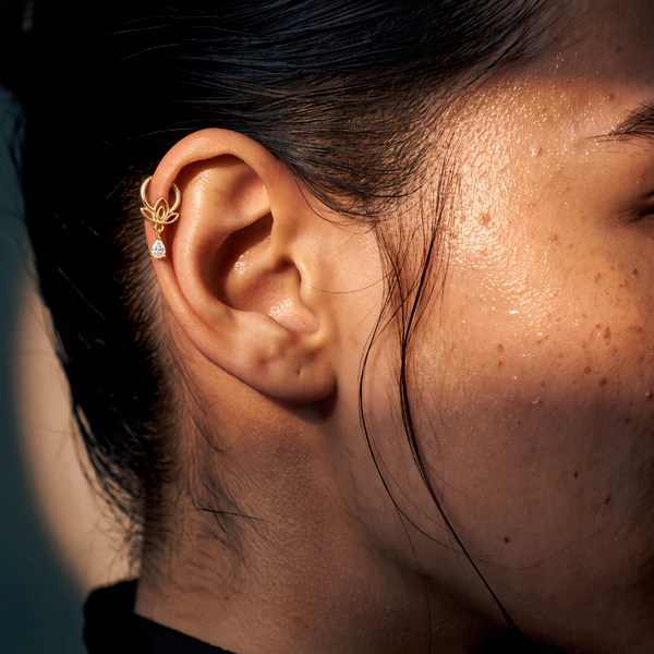 Anneau piercing Flora en titane gold, motif floral et zircon en goutte suspendu, zircon blanc, porté à l’hélix