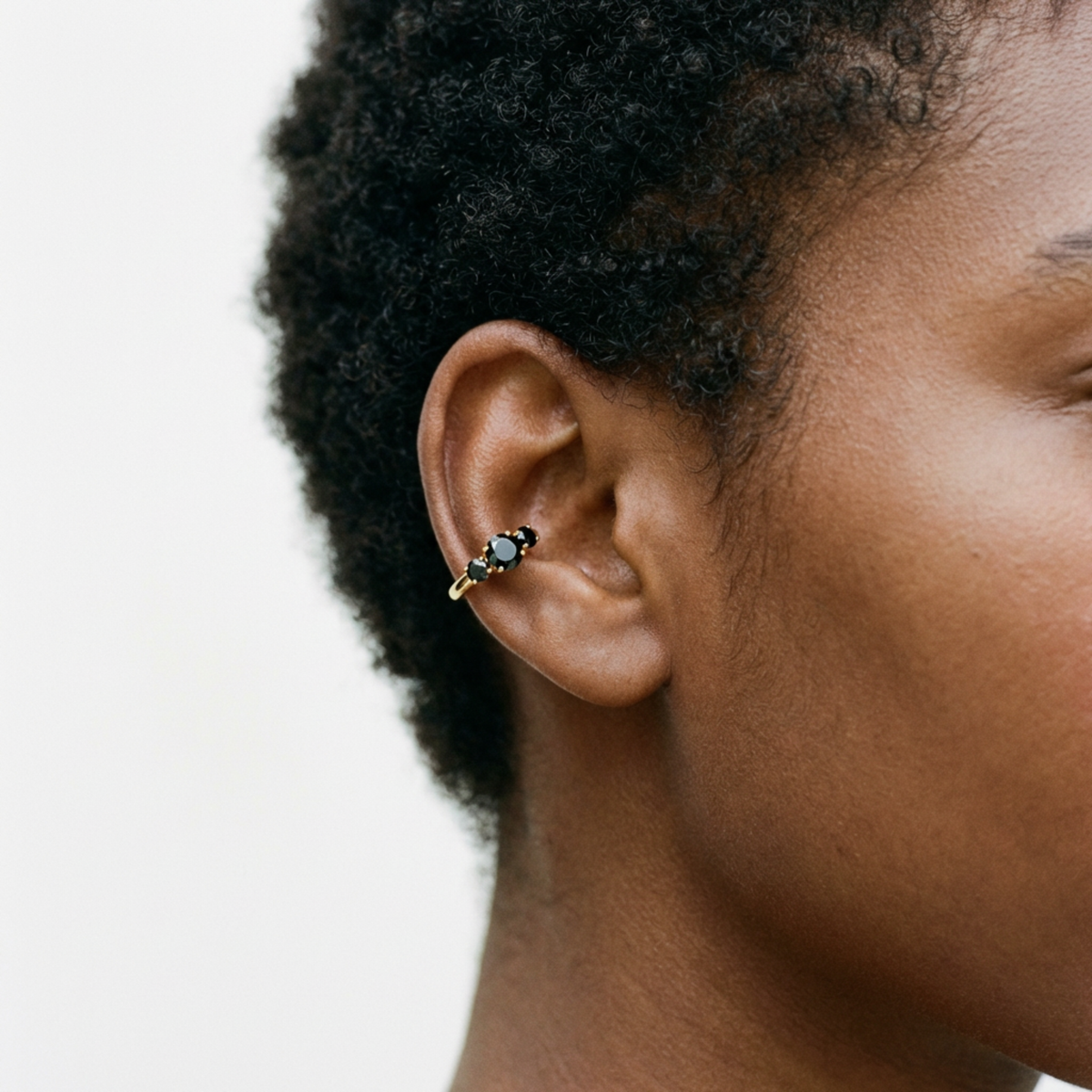 Anneau piercing Lazare en titane gold avec zircon, porté à l’oreille