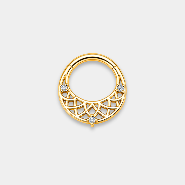 Anneau piercing Lumis en titane gold avec motifs géométriques ajourés et trois zircons sertis de face