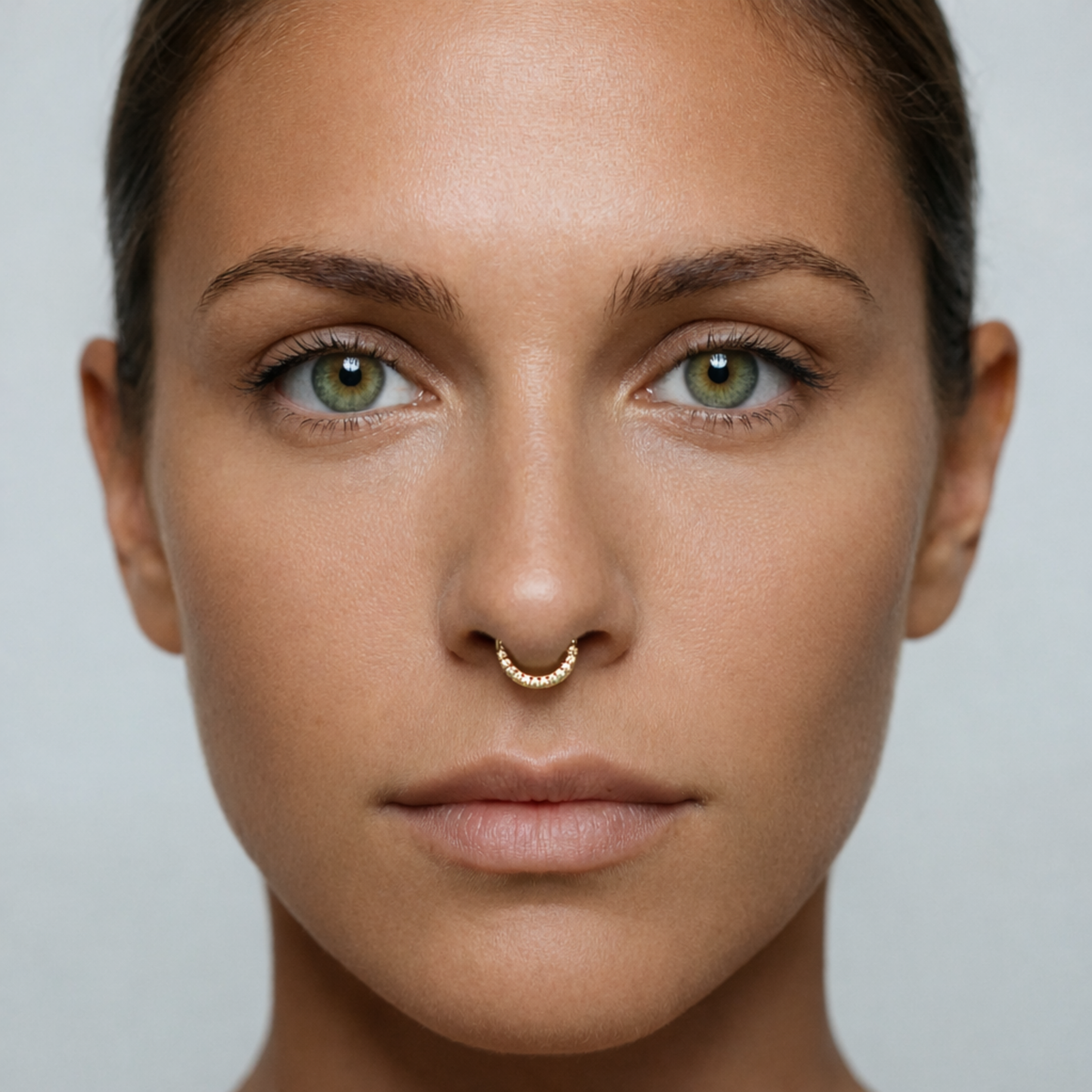 Anneau piercing Marla en titane gold avec zircon, porté au septum