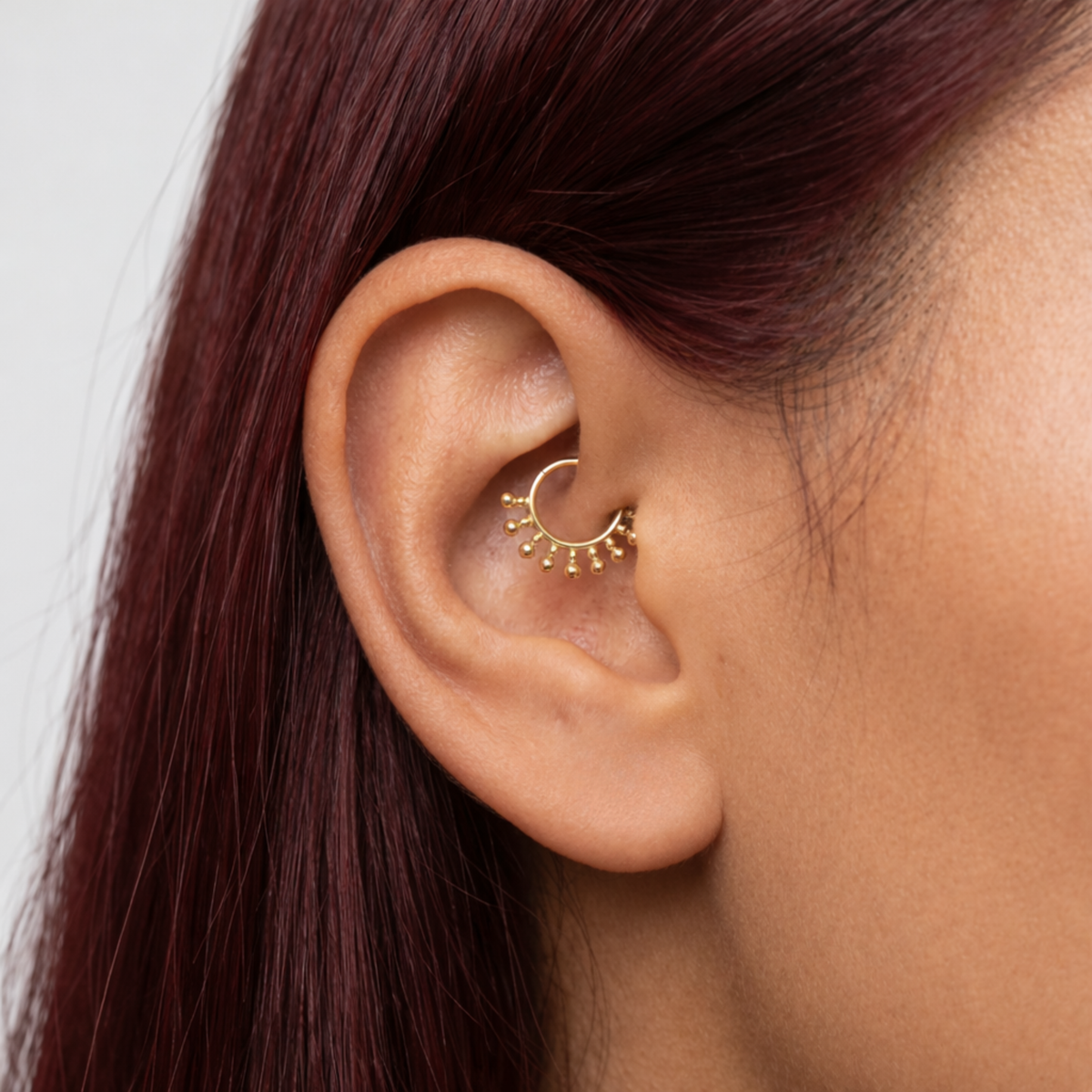 Anneau piercing Naelle en titane gold, porté à l’oreille