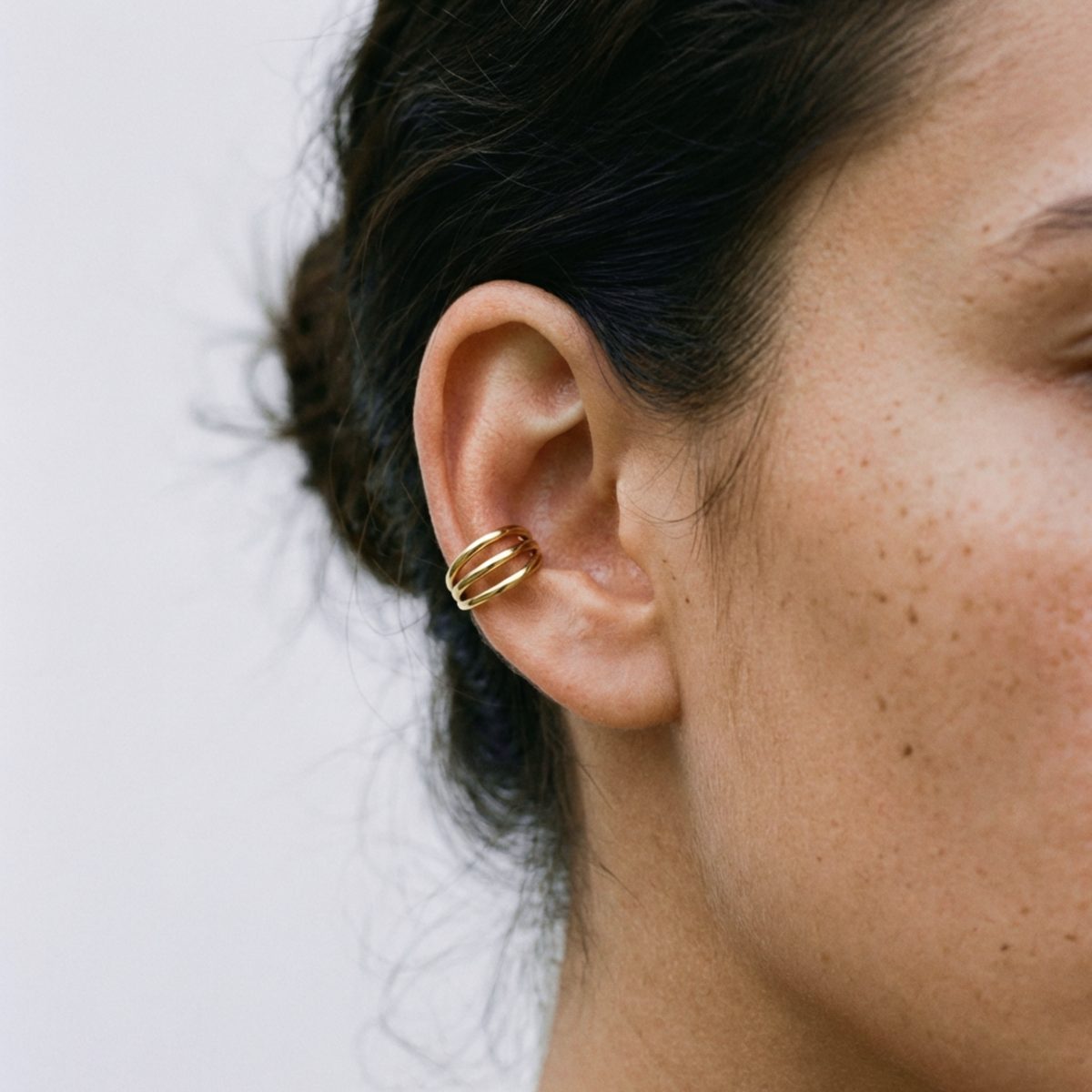 Anneau piercing Nolie en titane gold, porté à l’oreille