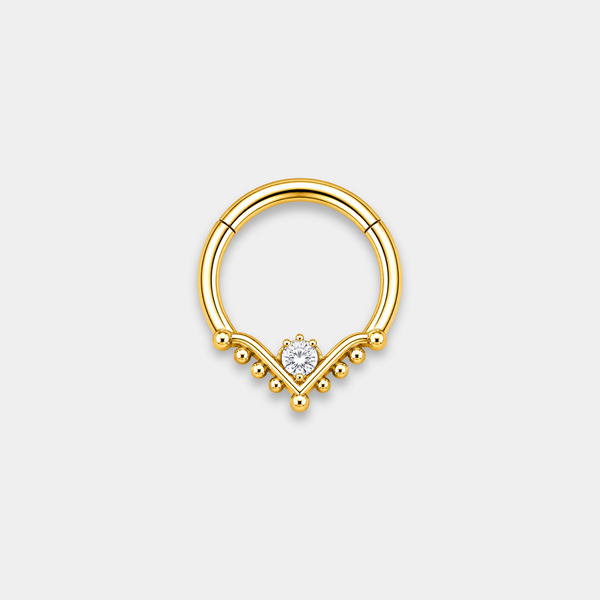 Anneau piercing Raya en titane gold avec zircon central serti et détails perlés en forme de V de face