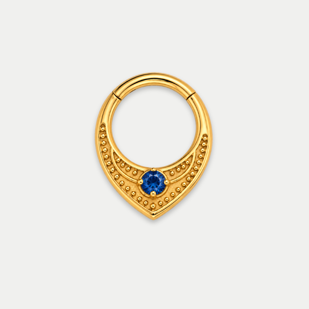 Anneau piercing Relief en titane gold, motif texturé perlé et zircon central, zircon bleu, vu de face