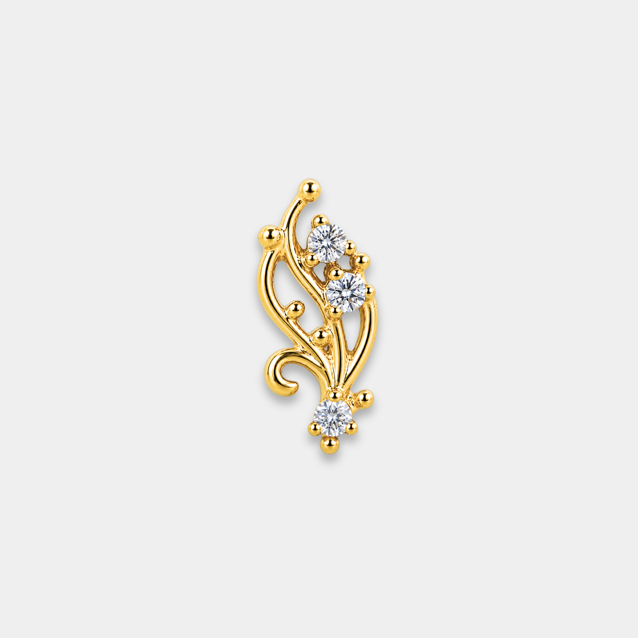 Embout piercing Brina en titane gold avec trois zircons sertis et courbes délicates inspirées de motifs végétaux de face