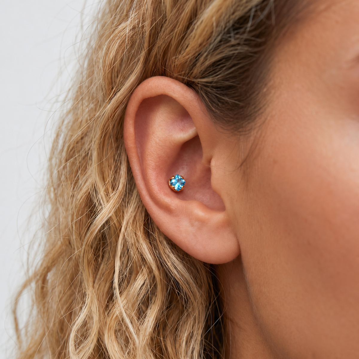 Embout piercing Iriséa en titane gold avec zircon, porté au conch