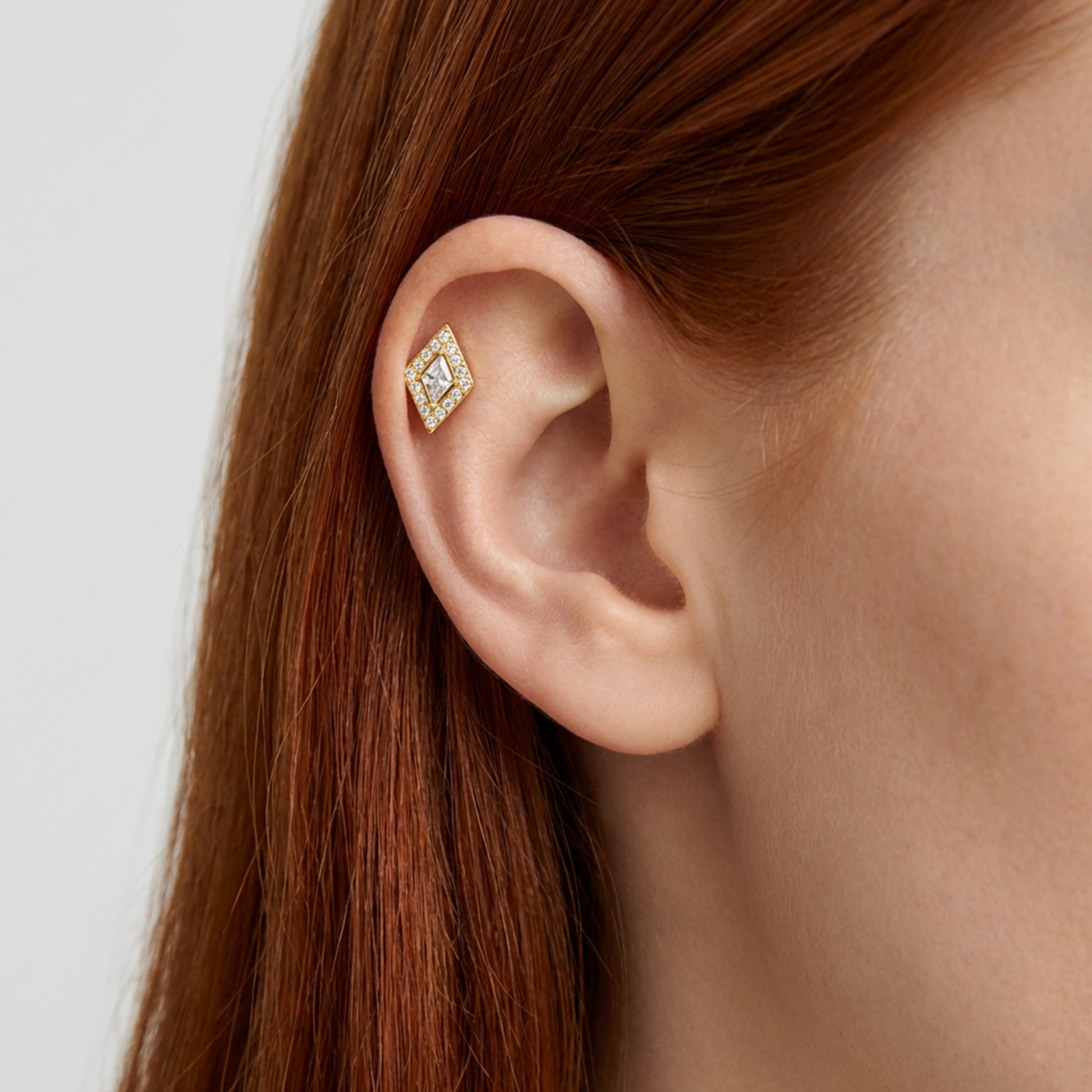 Embout de piercing en titane gold avec zircon losange porté à l’hélix de l’oreille