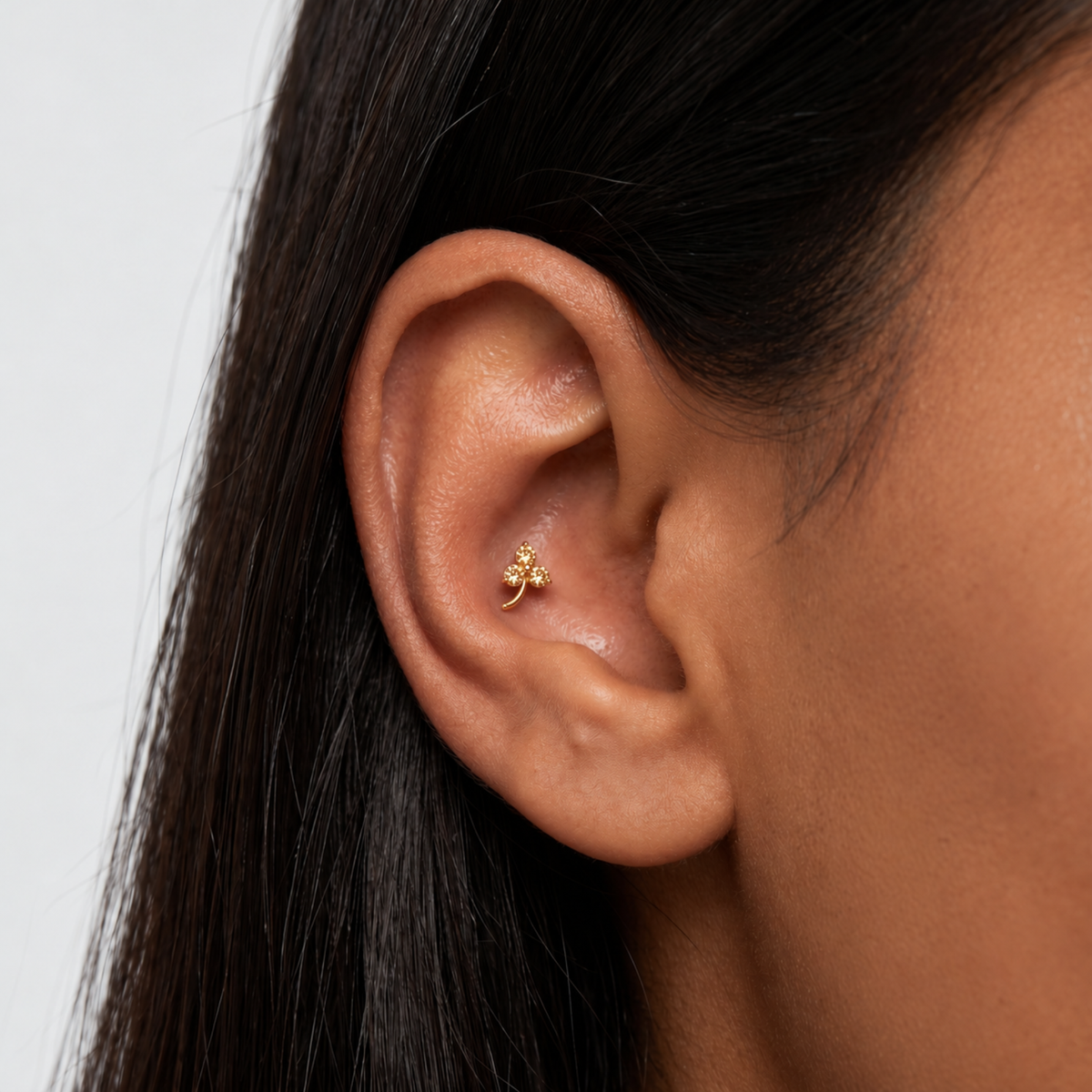 Embout piercing Nika en titane gold avec zircon, porté à l’oreille