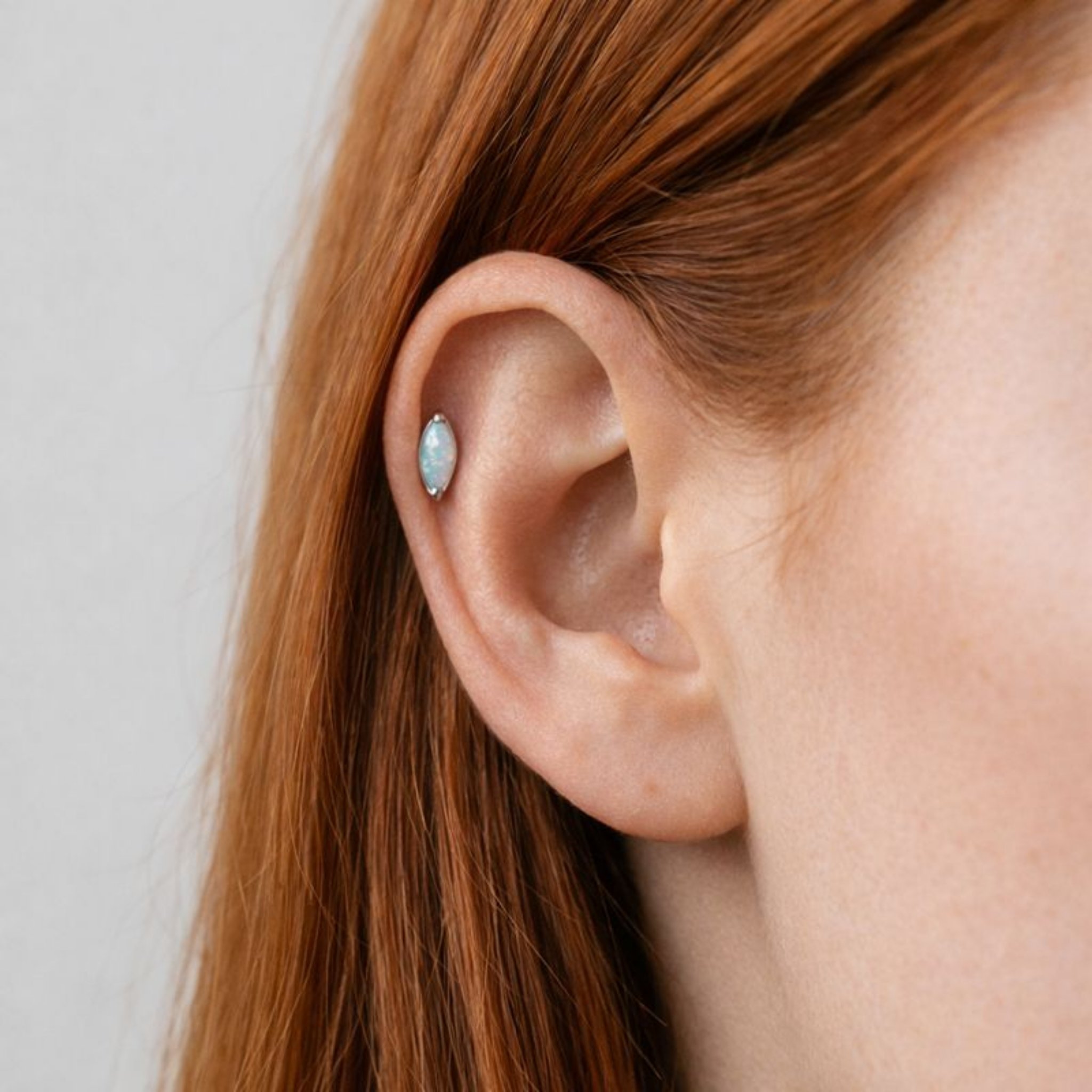Embout de piercing en titane avec opale marquise porté à l’hélix de l’oreille