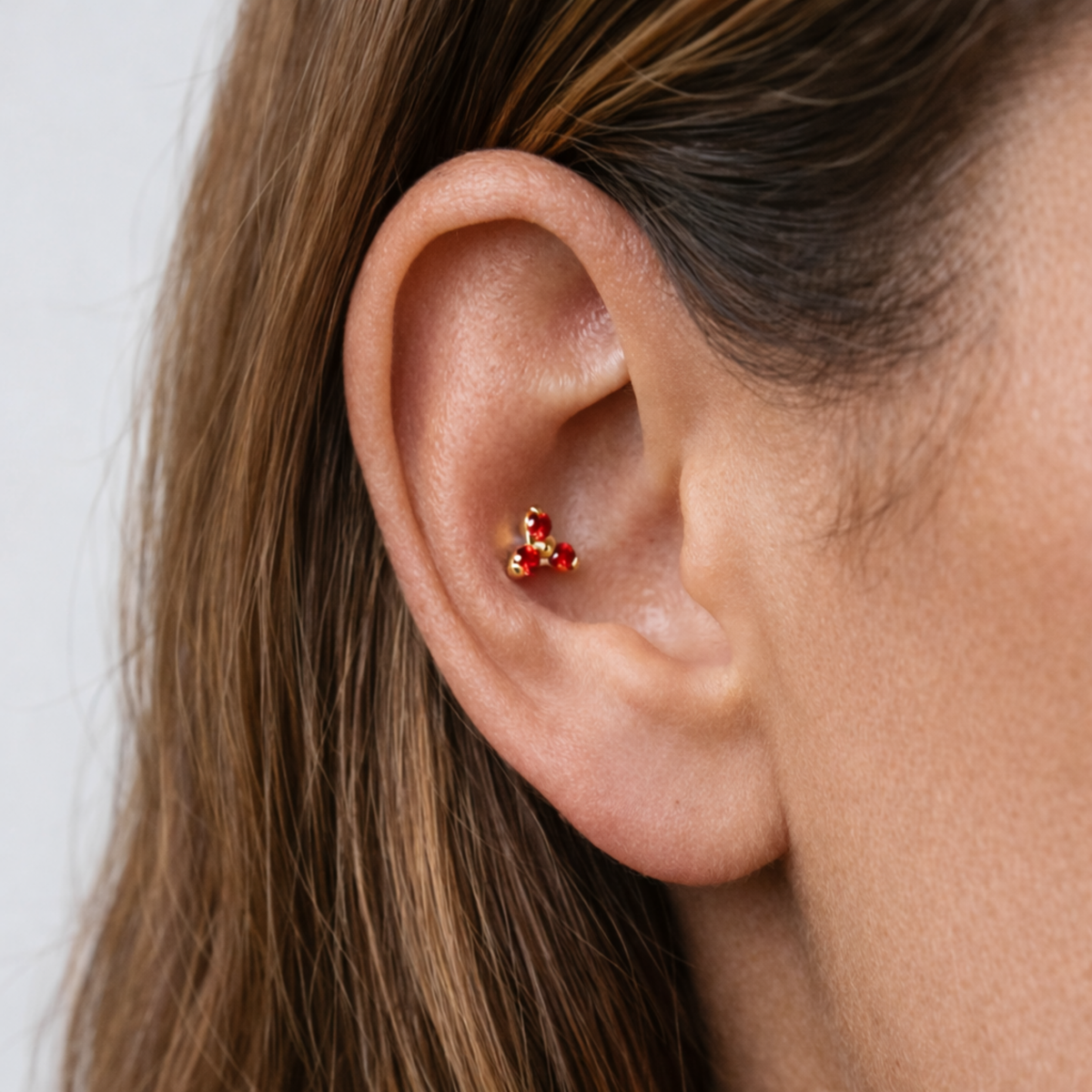 Embout piercing Selia en titane gold avec zircon, porté à l’oreille