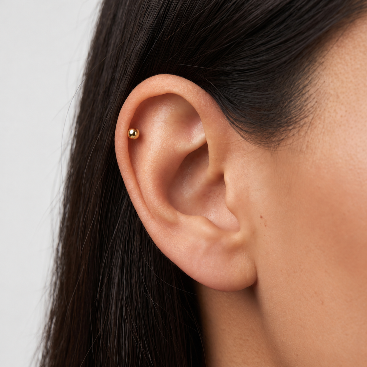 Embout piercing en titane gold avec bille, porté à l’hélix