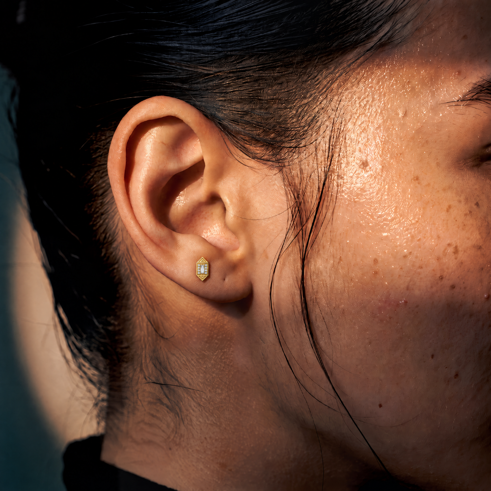 Embout piercing Vector en titane gold, zircon baguette entouré de zircons ronds, porté au lobe